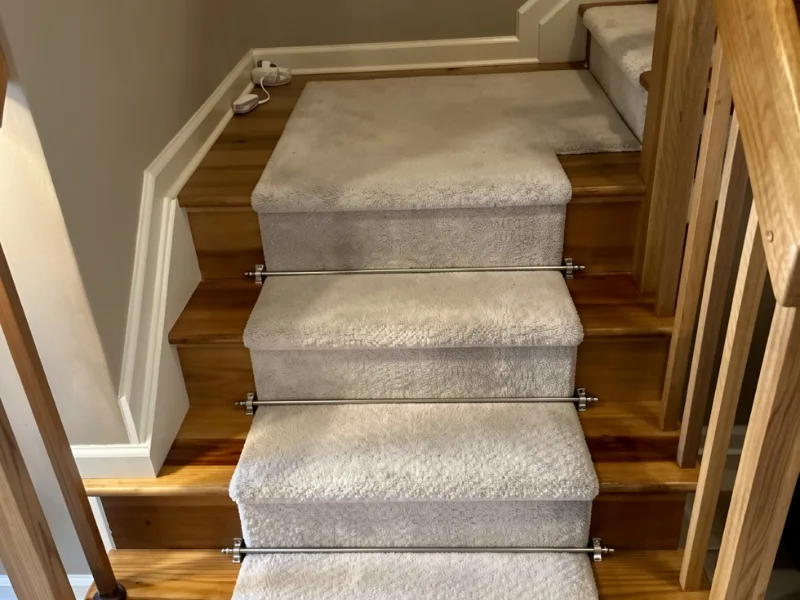 Carpeted wooden stairs with metal rods securing the carpet in place.